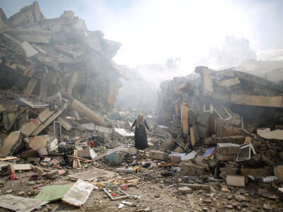 A resident gets upset as she walks amid near the rubble of residential buildings after Israeli airstrikes at al-Zahra neighborhood in Gaza Strip on October 19, 2023.