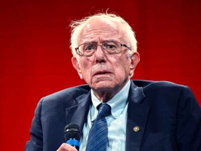Bernie Sanders looks bewildered while holding a microphone