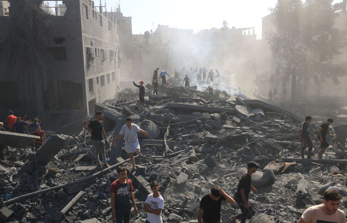 Palestinians search for survivors and the bodies of victims through the rubble of buildings destroyed during Israeli bombardment, in Khan Yunis in the southern Gaza Strip on October 26, 2023.