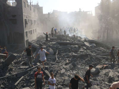Palestinians search for survivors and the bodies of victims through the rubble of buildings destroyed during Israeli bombardment, in Khan Yunis in the southern Gaza Strip on October 26, 2023.