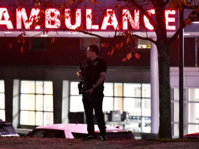 An armed police officer guards the ambulance entrance to the Central Maine Medical Center in Lewiston, Maine, early on October 26, 2023.