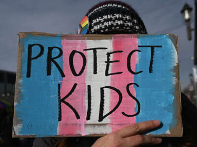 An LGBTQ+ supporter holds a placard during a protest on October 20, 2023, in Edmonton, Canada.