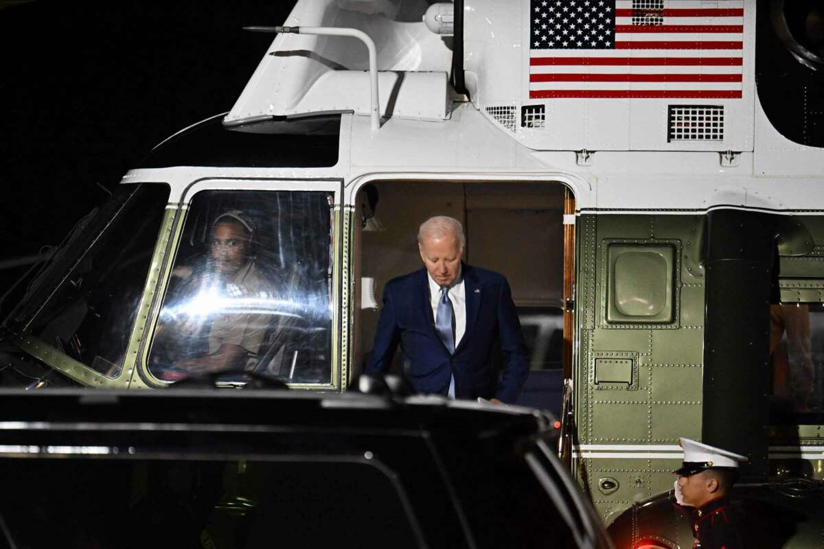 President Joseph Robinette Biden steps off of a helicopter bearing an image of the U.S. flag