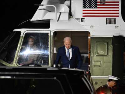 President Joseph Robinette Biden steps off of a helicopter bearing an image of the U.S. flag
