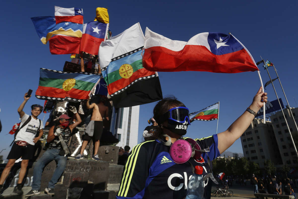 Demonstrators wave Chilean and Indigenous flags during a protest in Chile