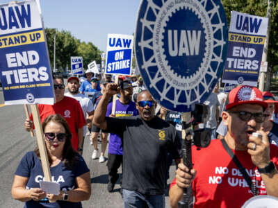 Striking United Auto Workers march in front of the Stellantis Mopar facility in Ontario, California