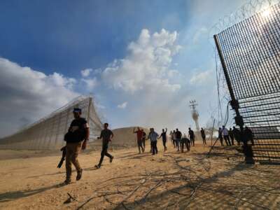Palestinian fighters enter the Israeli side of the destroyed border fence in Gaza City, Gaza on October 7, 2023.
