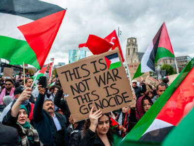 A protester holds a placard saying "This is not war, This is Genocide" during a demonstration in solidarity with the Palestinian people in Rotterdam, Netherlands, on October 22, 2023.