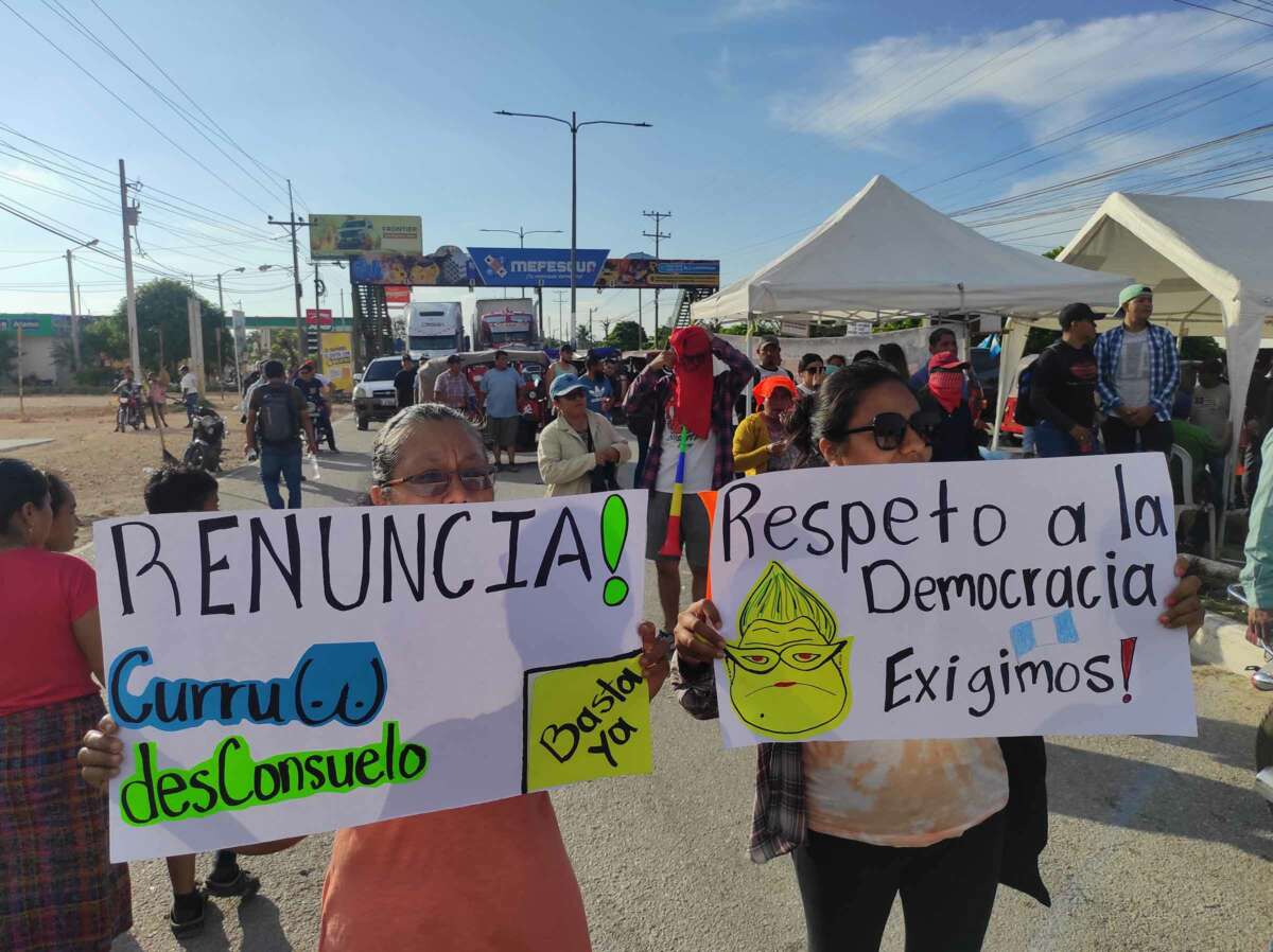 At a protest in Santa Elena, Petén, Imelda Mejía (left) and her daughter hold up signs calling for the attorney general and another prosecutor to resign.