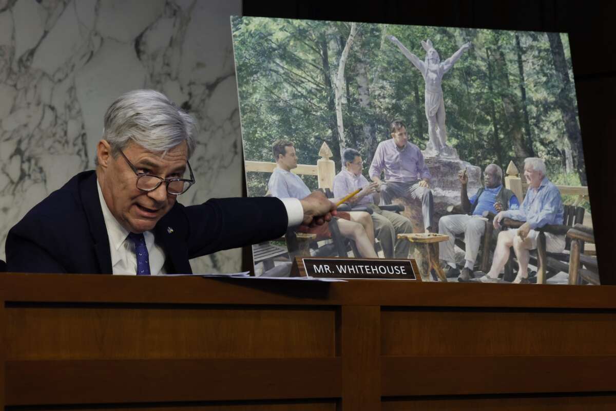 Sen. Sheldon Whitehouse displays a copy of a painting featuring Supreme Court Justice Clarence Thomas alongside other conservative leaders during a hearing on Supreme Court ethics reform on May 02, 2023 in Washington, D.C. The painting was commissioned by billionaire Texas Republican real estate developer Harlan Crow.