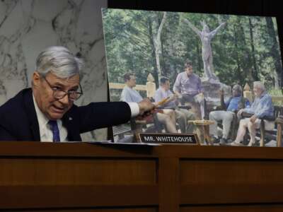 Sen. Sheldon Whitehouse displays a copy of a painting featuring Supreme Court Justice Clarence Thomas alongside other conservative leaders during a hearing on Supreme Court ethics reform on May 02, 2023 in Washington, D.C. The painting was commissioned by billionaire Texas Republican real estate developer Harlan Crow.