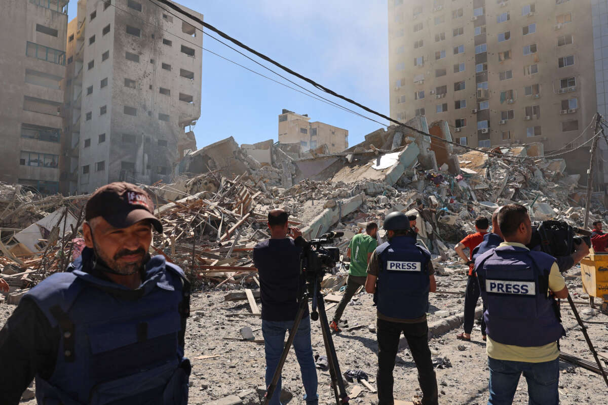 Palestinian journalists cover the destroyed Jala Tower, which was housing international press offices, following an Israeli airstrike in the Gaza Strip, on May 15, 2021.
