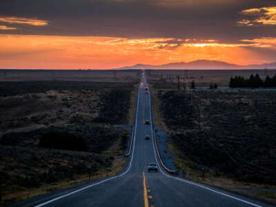 Road going off into distant mountains, sunset.