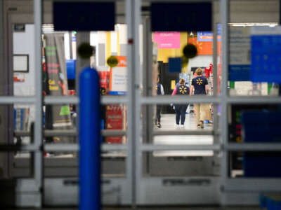 Walmart employees walk down an aisle on November 29, 2019, in Highlands Ranch, Colorado.