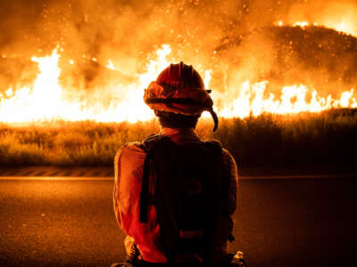 A CalFire firefighter watches as the Rabbit Fire spreads in Moreno Valley, California, on July 14, 2023.