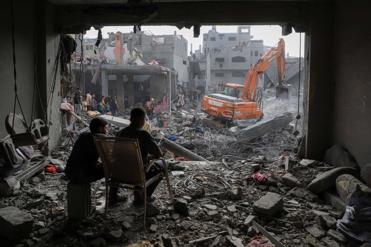 An excavator works on destroyed buildings after Israeli airstrikes in the Southern Gaza Strip city of Khan Younis, on October 25, 2023.