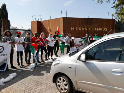 Pro-Palestinian supporters and activists stop a vehicle from entering while protesting outside the Paramount Group offices in Midrand, north of Johannesburg, on November 10, 2023.