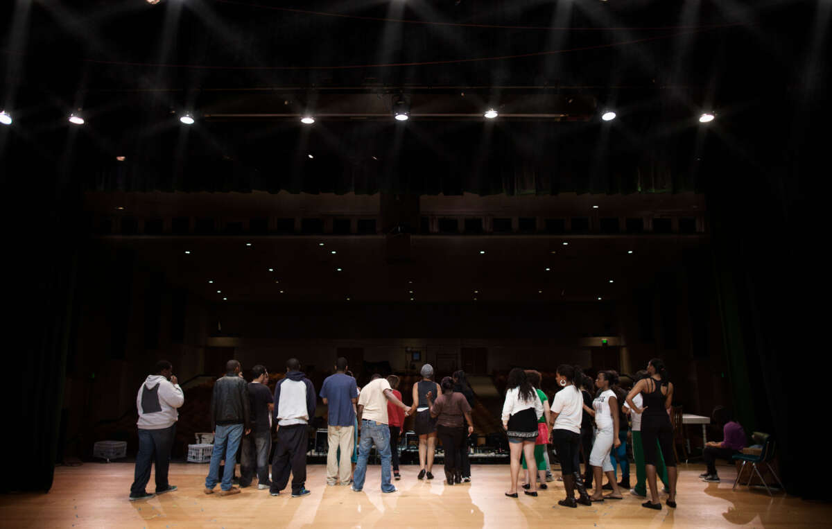 School play, teens rehearsing on stage, facing away