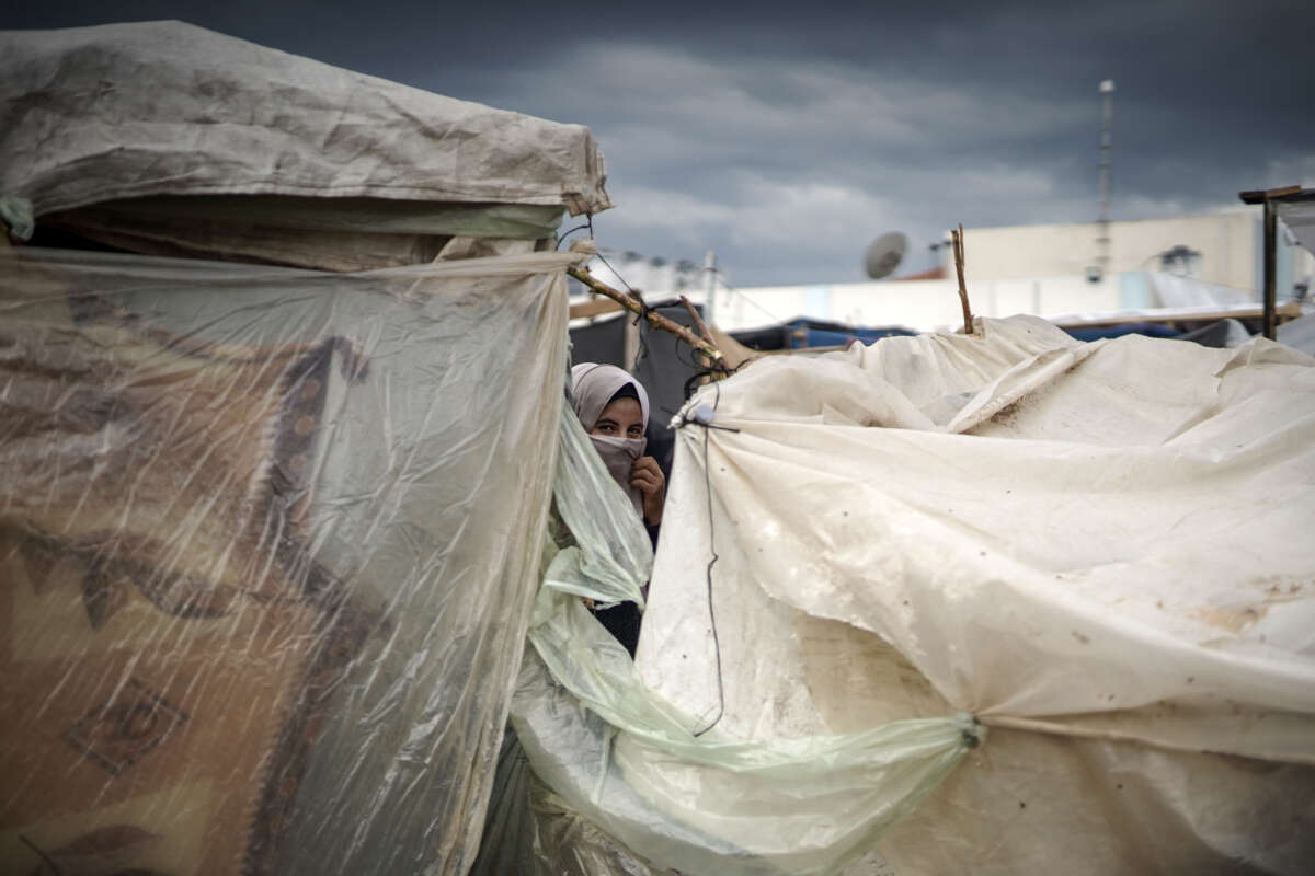 A woman looks among the tents covering by nylon at the United Nations Relief and Works Agency (UNRWA) refugee camp located in Khan Yunis, Gaza, where displaced Palestinian families take shelter and try to maintain their daily lives under harsh conditions amid the Israeli attacks on Gaza, on November 15, 2023.