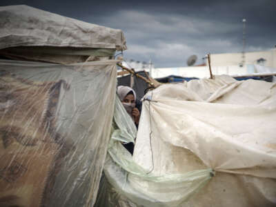 A woman looks among the tents covering by nylon at the United Nations Relief and Works Agency (UNRWA) refugee camp located in Khan Yunis, Gaza, where displaced Palestinian families take shelter and try to maintain their daily lives under harsh conditions amid the Israeli attacks on Gaza, on November 15, 2023.