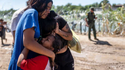 A family is overcome with emotion after crossing the U.S.-Mexico border on September 28, 2023, in Eagle Pass, Texas.