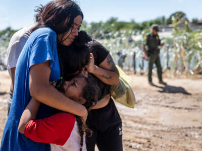 A family is overcome with emotion after crossing the U.S.-Mexico border on September 28, 2023, in Eagle Pass, Texas.