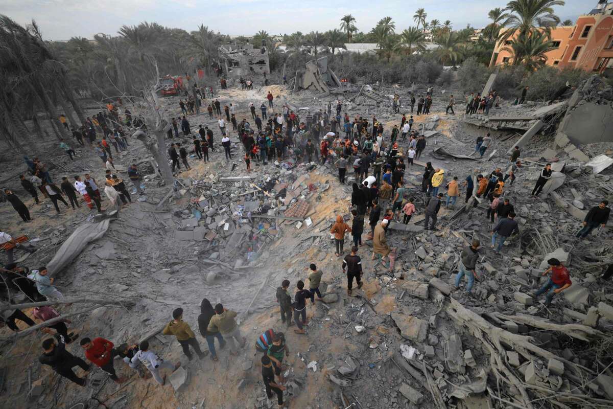 People gather among the rubble of what was once their neighborhood