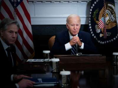 Joe Biden sits next to Anthony Blinken