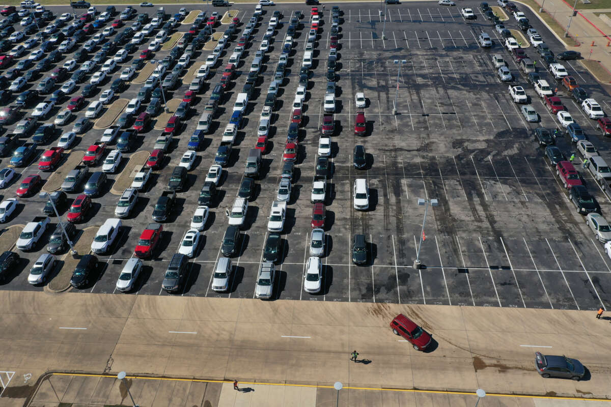 An aerial view shows cars lined up in a parking lot as people wait to be directed to a food distribution point setup at Del Valle High School on February 20, 2021, in Austin, Texas.