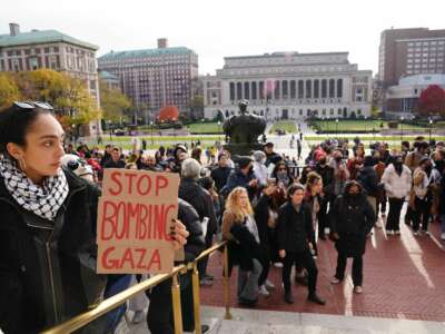 A pro-Palestinian student protester holds a sign saying "Stop bombing Gaza" at Columbia University