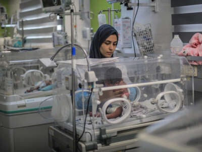 A newborn infant receives care inside an incubator in Gaza