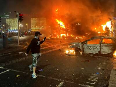 Flames rise from a car and a bus, set alight at the junction of Bachelors Walk and the O'Connell Bridge in Dublin, on November 23, 2023.