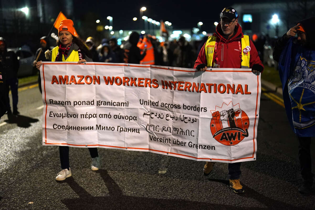 Amazon workers hold up a banner that says "Amazon workers international"