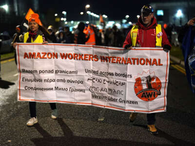 Amazon workers hold up a banner that says "Amazon workers international"