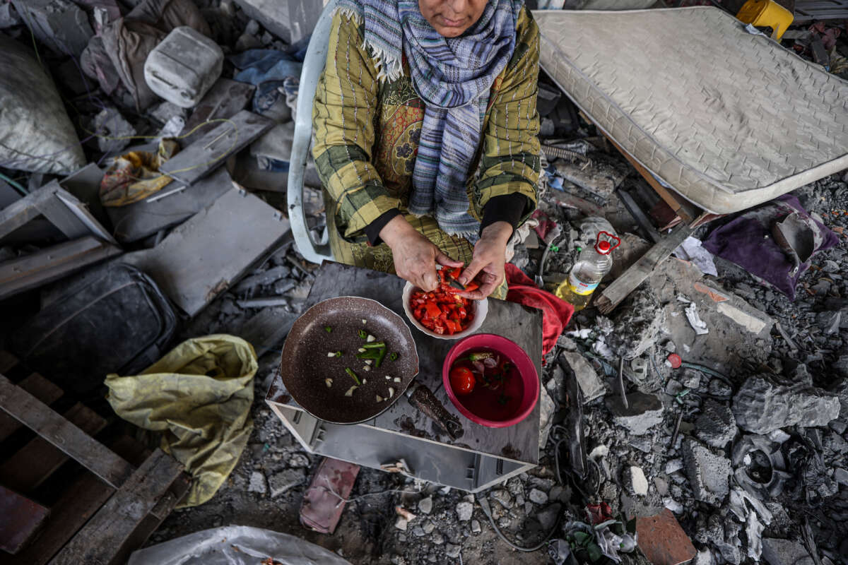 Haleed Naci and his family cook food among the rubble and debris of their family house destroyed by Israeli attacks in Deir al Balah, Gaza, on November 25, 2023.