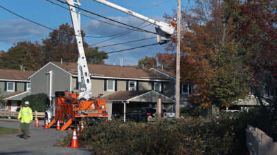 Crews work on utility poles while trying to restore power in Maine