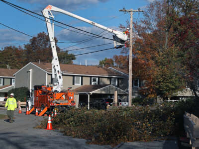 Crews work on utility poles while trying to restore power in Maine