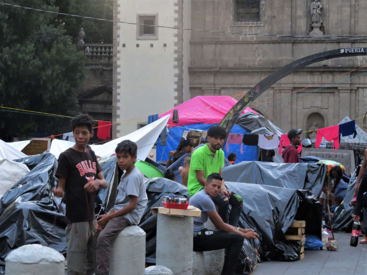 Janaiker Guerra (green t-shirt) at the migrant encampment outside a church in Mexico City