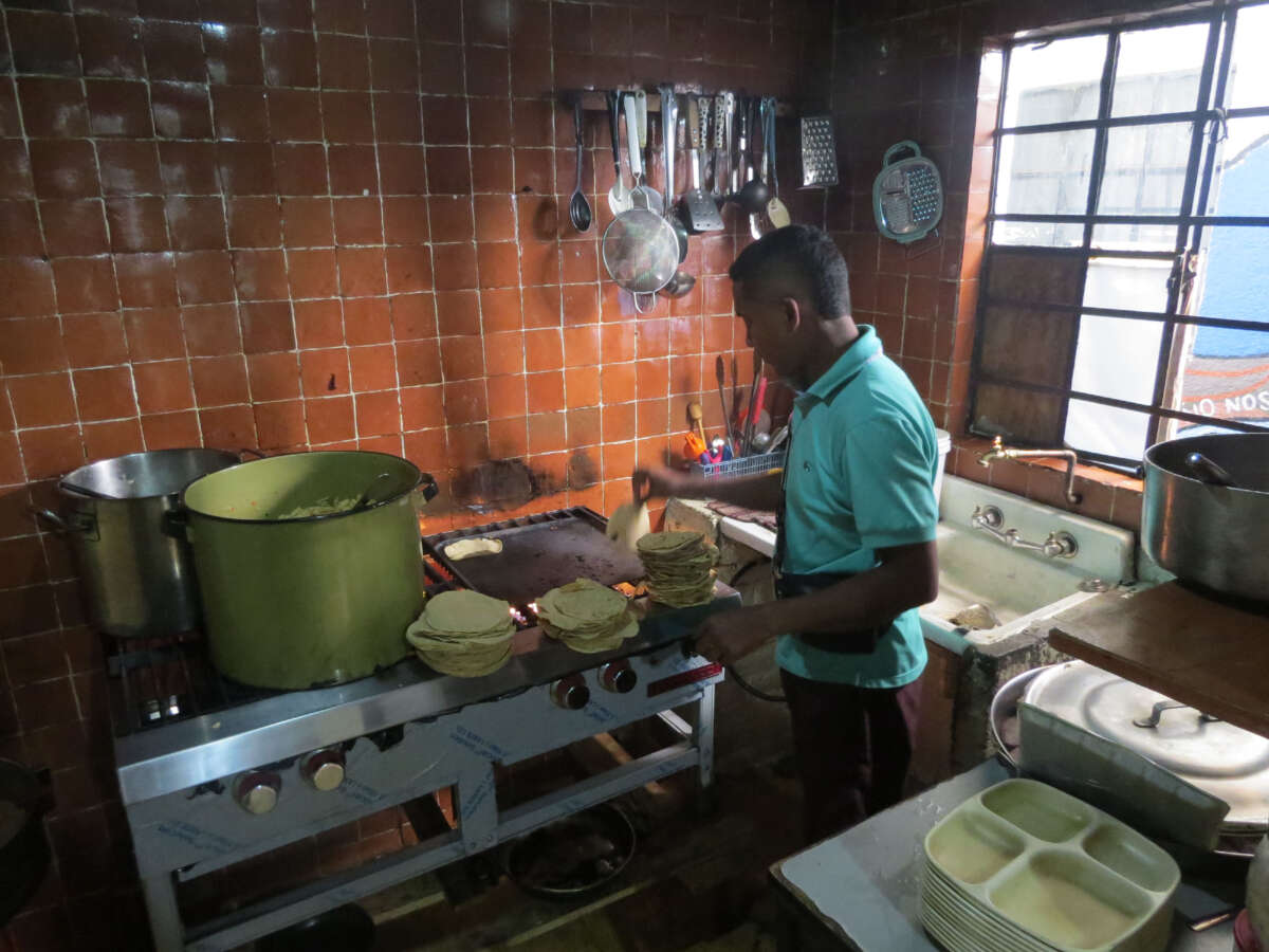 A migrant prepares lunch in the kitchen of the Casa Tochan shelter.