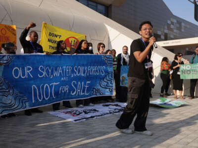 Activists protest against what they call the sham of carbon offsetting on day eight of the COP28 climate conference at Expo City Dubai on December 8, 2023, in Dubai, United Arab Emirates.