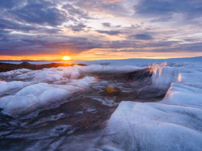 Brown sediment is seen on the ice sheet, created by rapid melting, in February, 2023, near Kangerlussuaq, in Greenland.