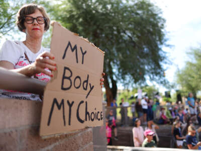 A protestor holds a sign reading 'My Body My Choice' at a Women's March rally outside the State Capitol on October 8, 2022, in Phoenix, Arizona.