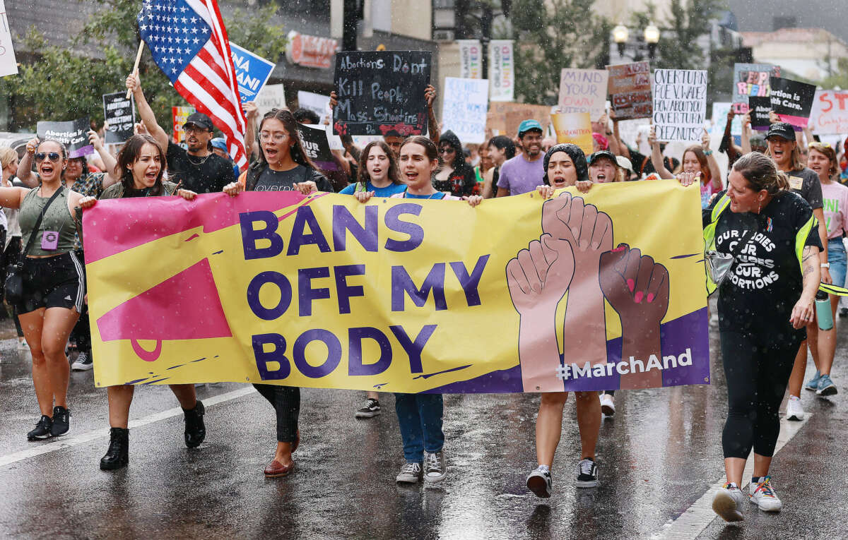 Demonstrators march in the rain during an abortion rights rally in downtown Orlando, Florida, on June 27, 2022.