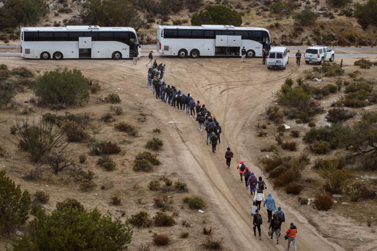 Aerial view of asylum seekers standing in line to be transported to a U.S. Border Patrol processing center after crossing the nearby border with Mexico near the Jacumba Hot Springs on November 30, 2023, in San Diego, California.