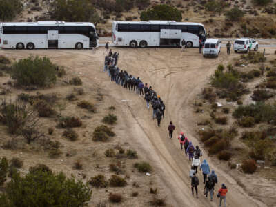 Aerial view of asylum seekers standing in line to be transported to a U.S. Border Patrol processing center after crossing the nearby border with Mexico near the Jacumba Hot Springs on November 30, 2023, in San Diego, California.