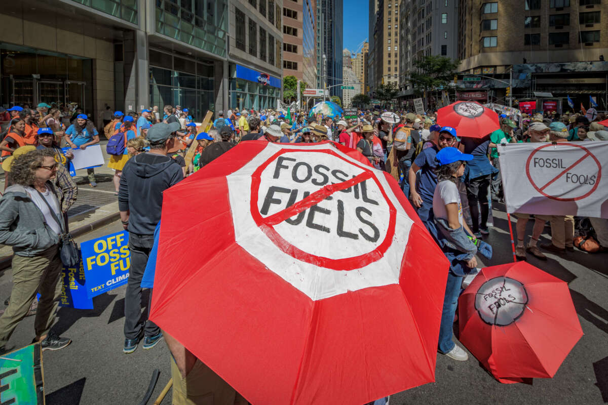 Participant seen using an umbrella as a protest sign at the March to End Fossil Fuels in New York City, on September 17, 2023.
