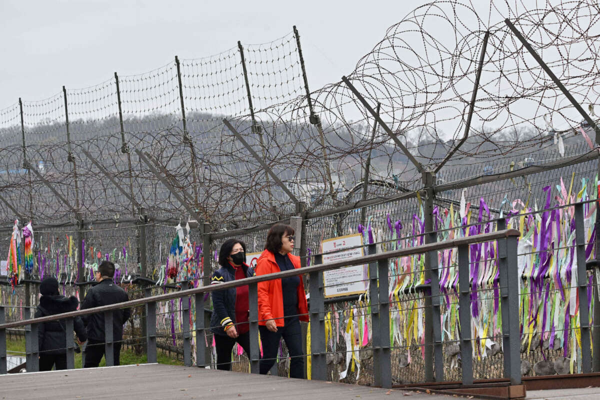 Visitors walk past a military fence at Imjingak peace park near the Demilitarized Zone (DMZ) dividing the two Koreas in Paju, South Korea, on November 22, 2023.