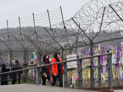 Visitors walk past a military fence at Imjingak peace park near the Demilitarized Zone (DMZ) dividing the two Koreas in Paju, South Korea, on November 22, 2023.