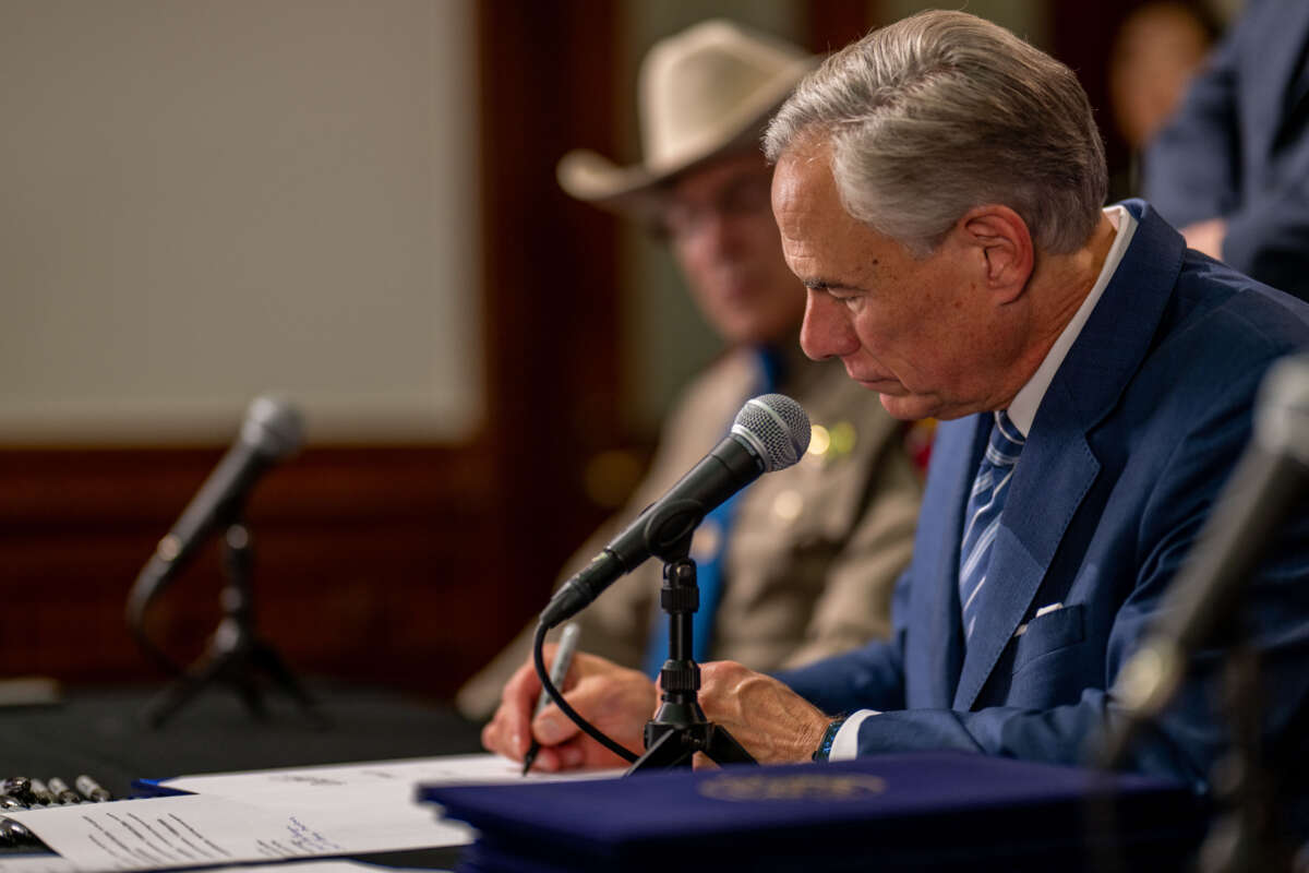 Texas Gov. Greg Abbott signs a bill during a news conference at the Texas State Capitol on June 8, 2023, in Austin, Texas.