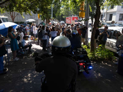 Police officers watch as Cop City protesters approach the Lewis R. Slaton Courthouse ahead of an expected indictment of former President Donald Trump in Atlanta, Georgia, on August 14, 2023.